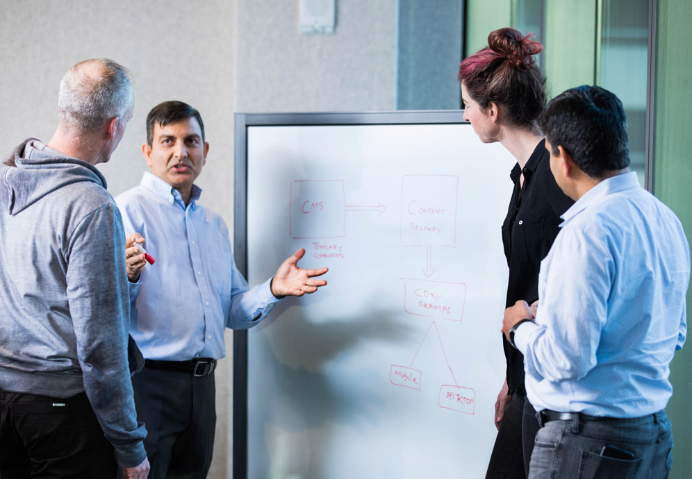A group of people gathered around a dry-erase board