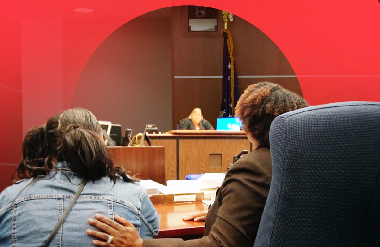 A woman with her defense attorney beside her in court
