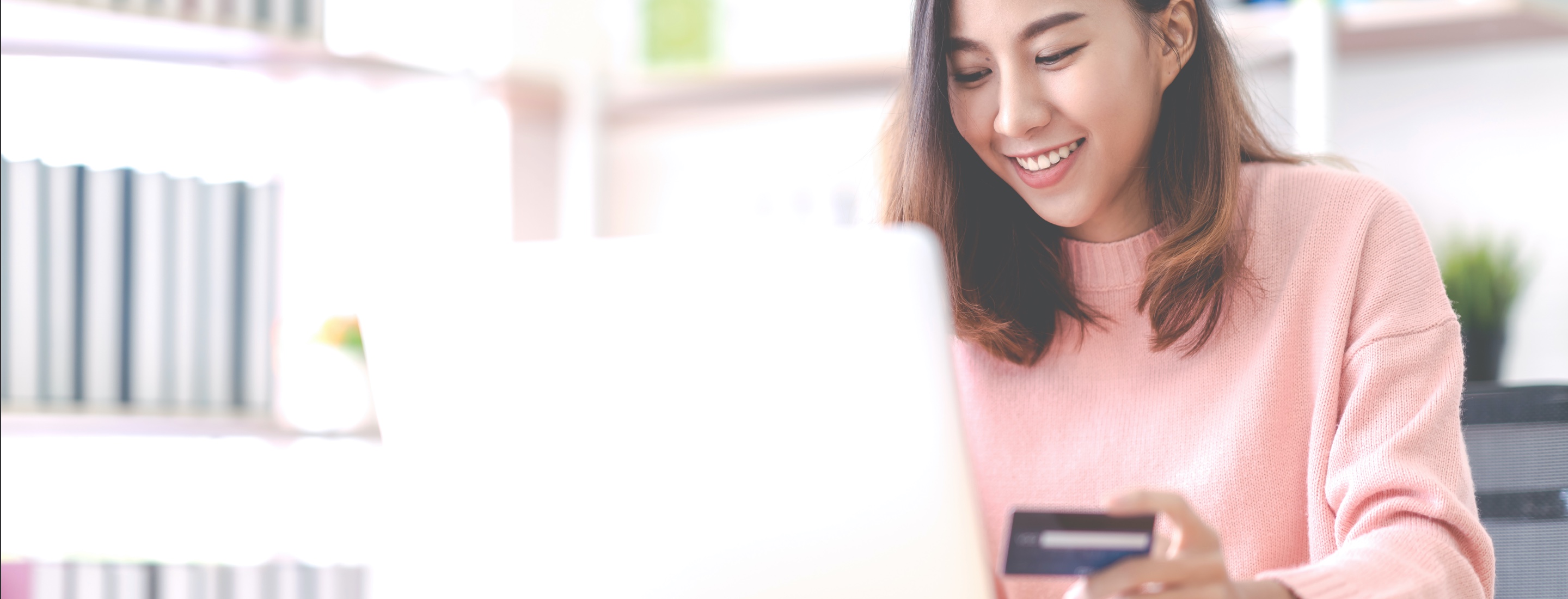 image of young woman with credit card shopping online at home