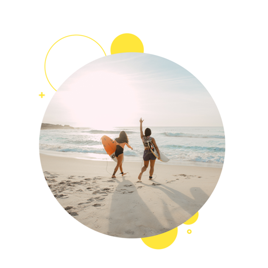 Two people getting ready to surf on the beach