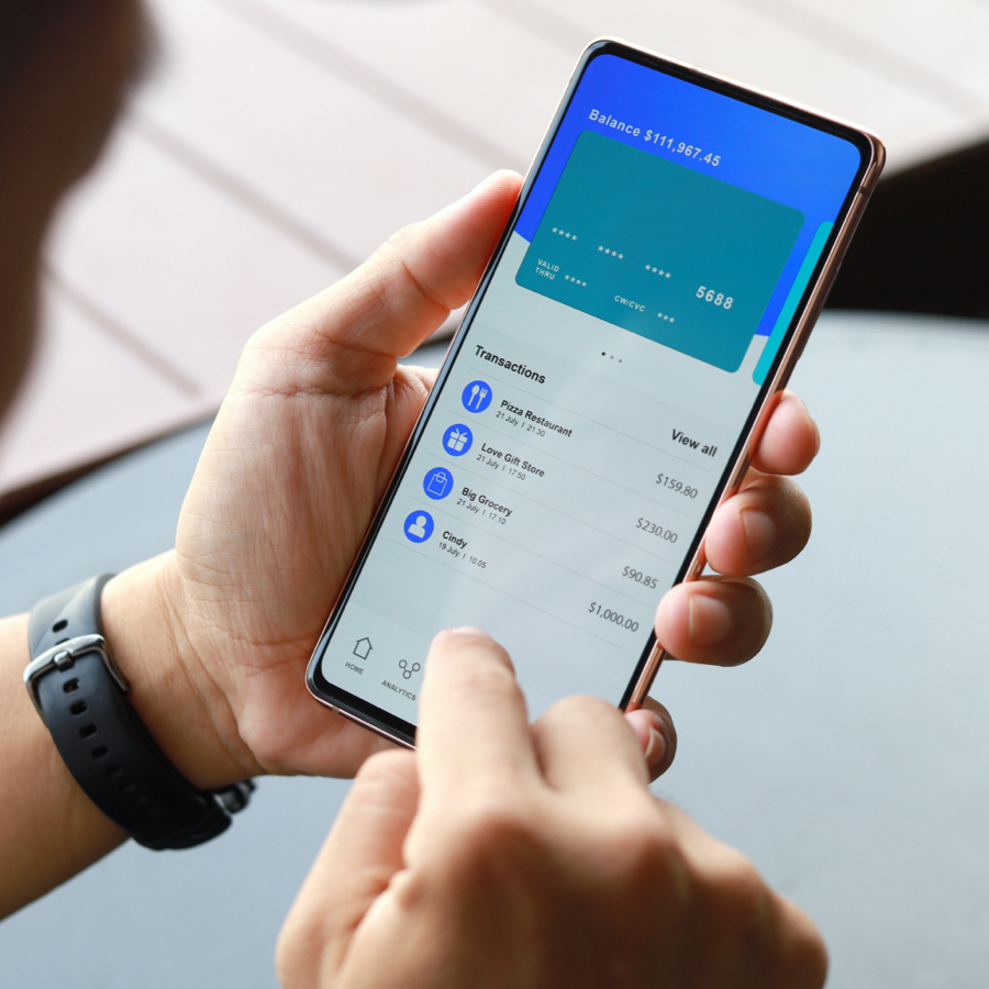 image alt tag: hand holding a mobile device using mobile banking app