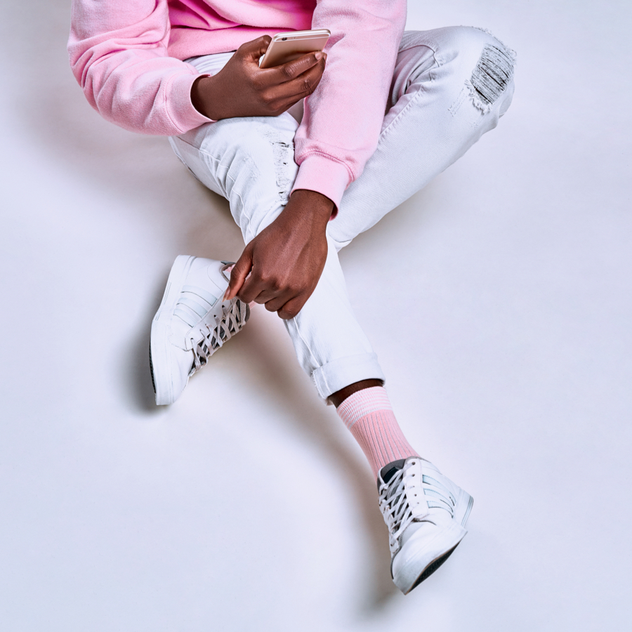 person wearing athletic clothes sitting down using their mobile device]