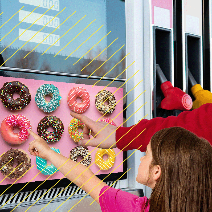 girl pointing to donuts on digital screen on fuel pump