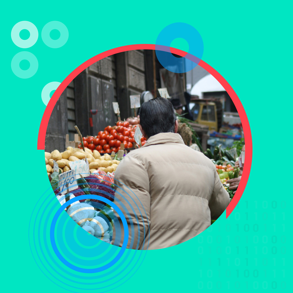 A person facing a fruit and vegetable shop