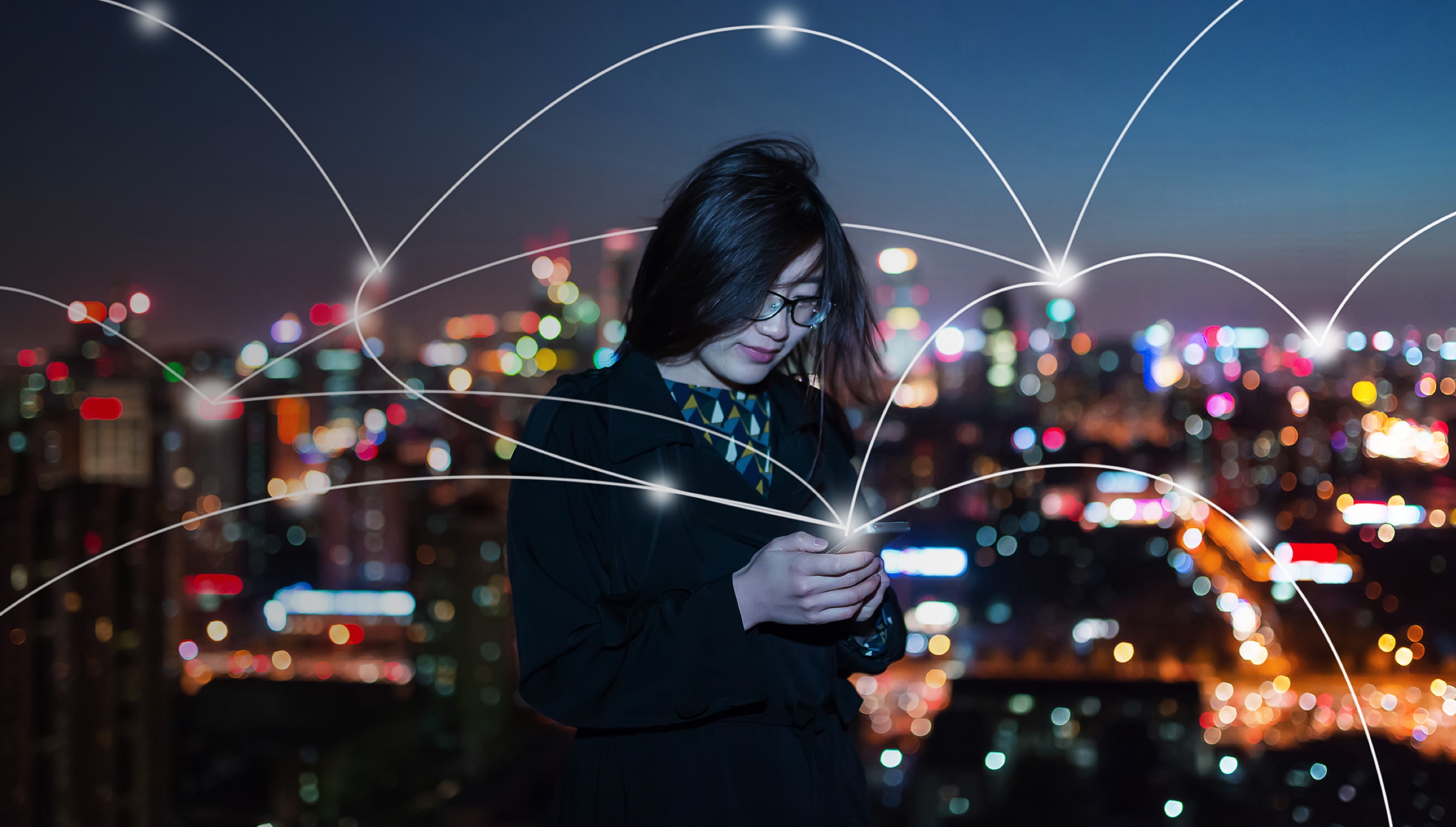 woman with mobile phone in front of a city that appears to be digitally connected