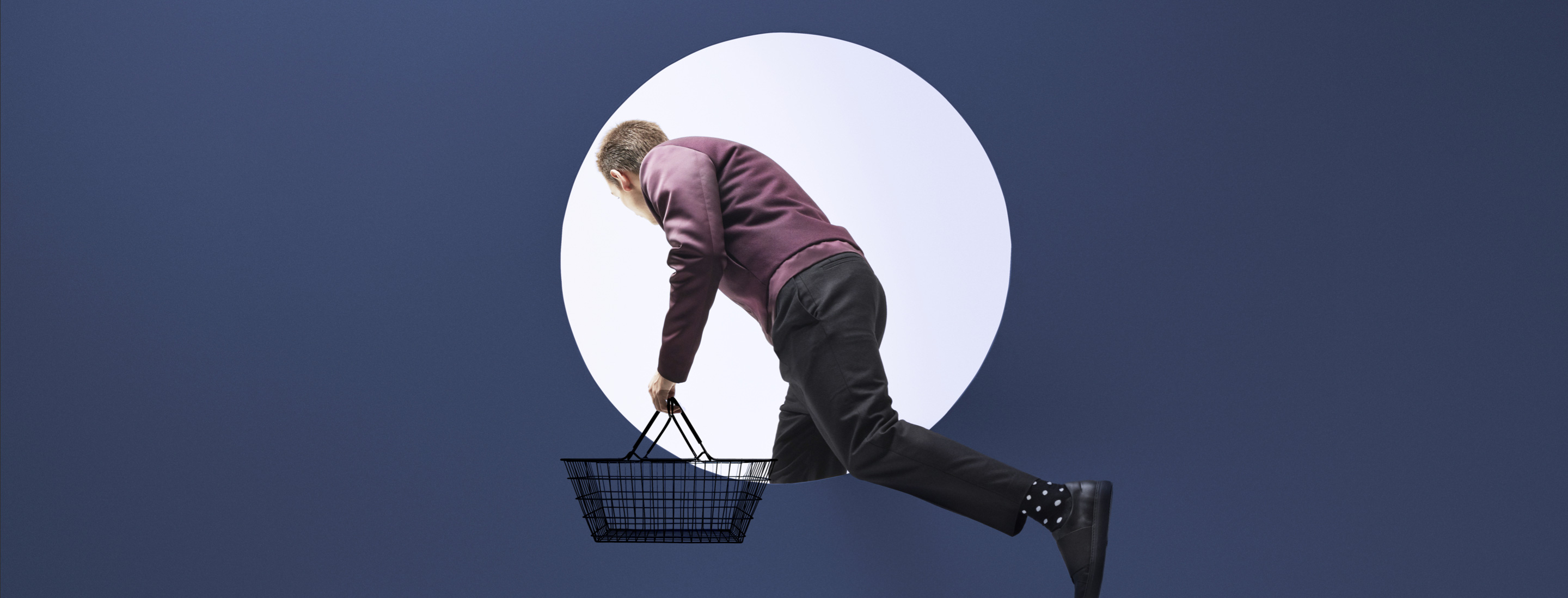 Man with shopping cart stepping through a window