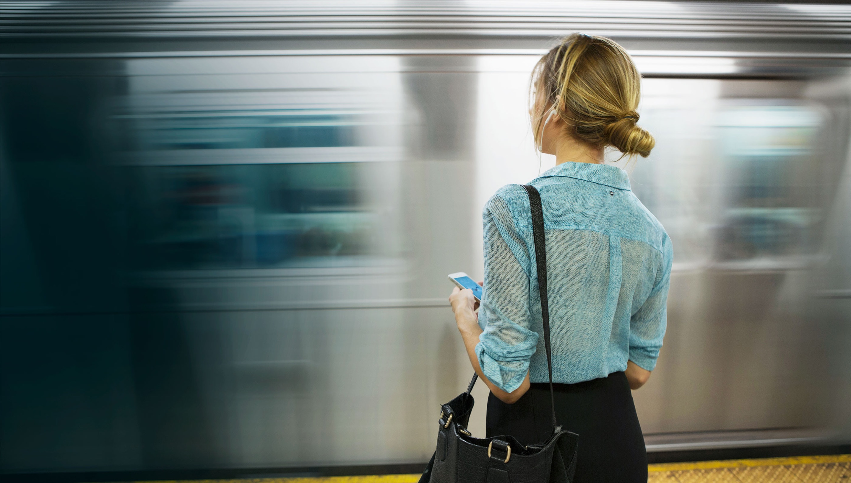 Person watching a subway train speed past.