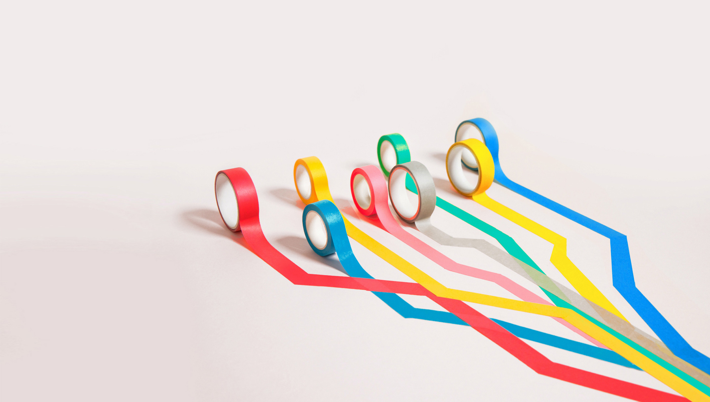multi-colored rolls of tape unrolling side-by-side