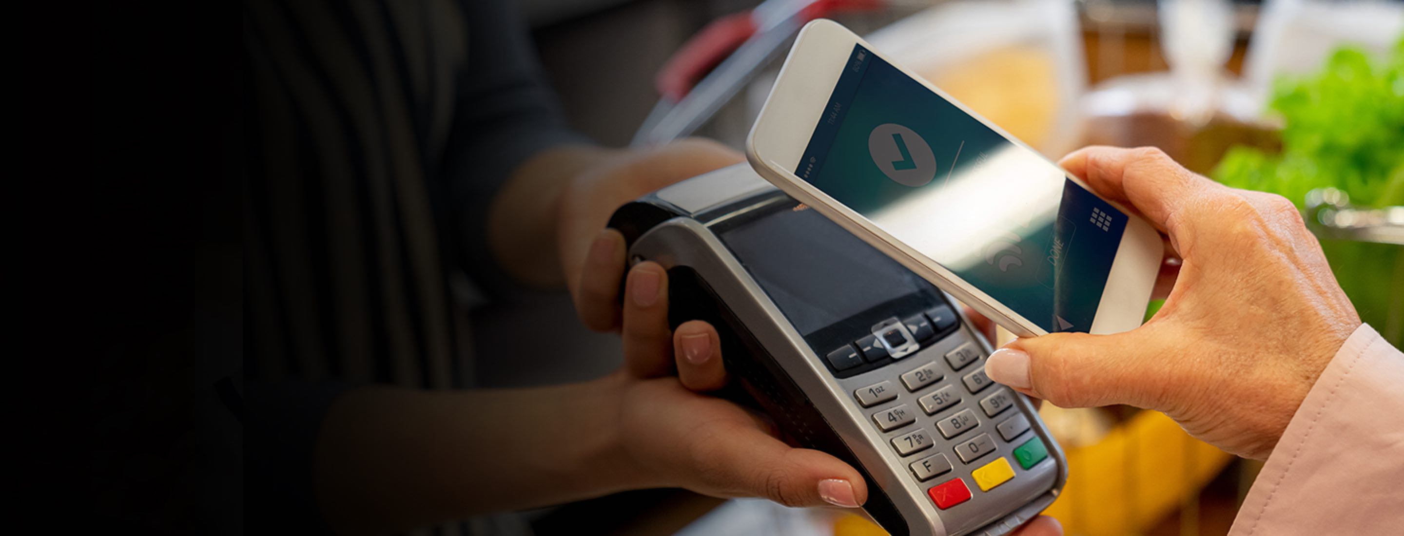 Customer paying with phone in checkout aisle