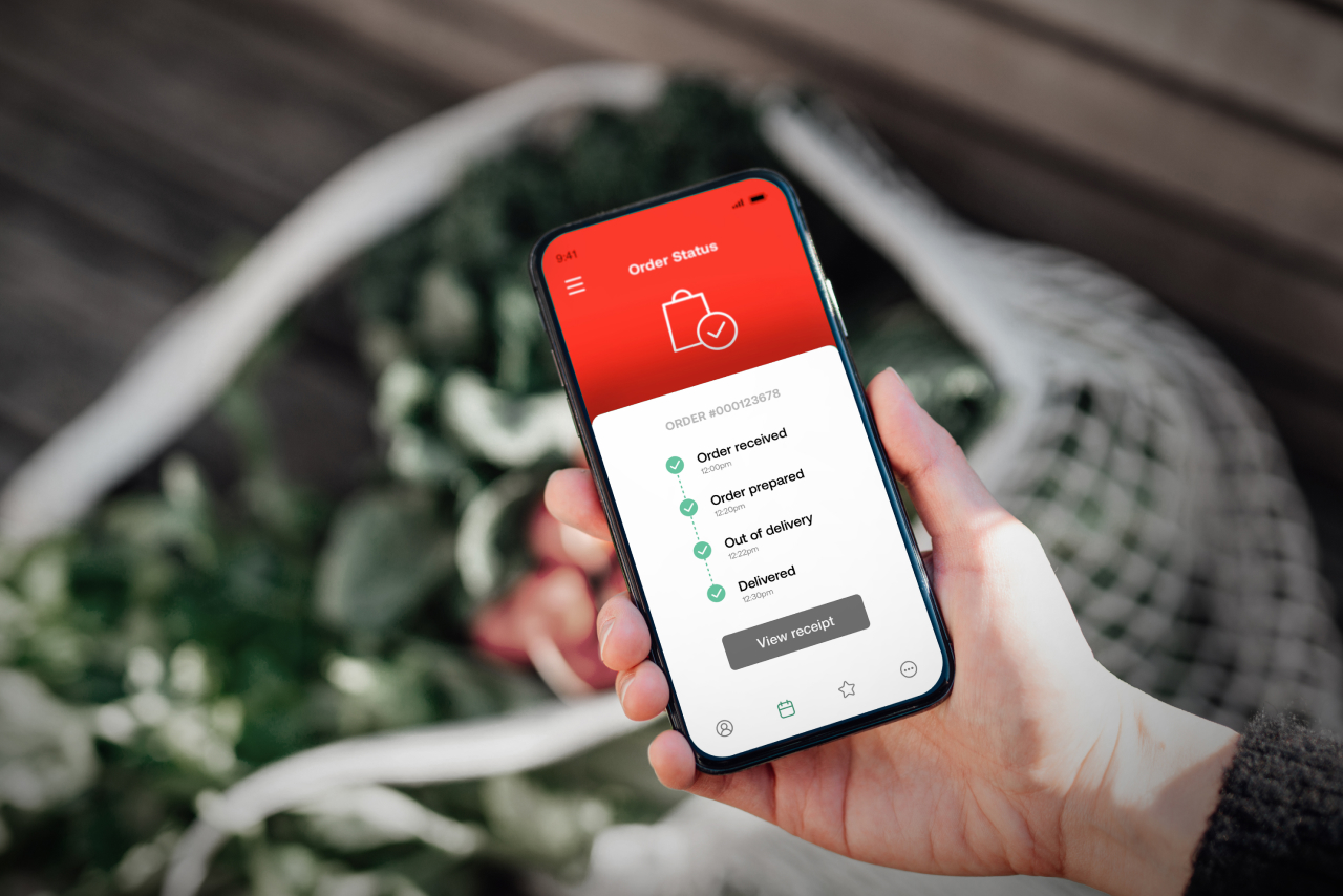 Hand holding phone showing transaction data