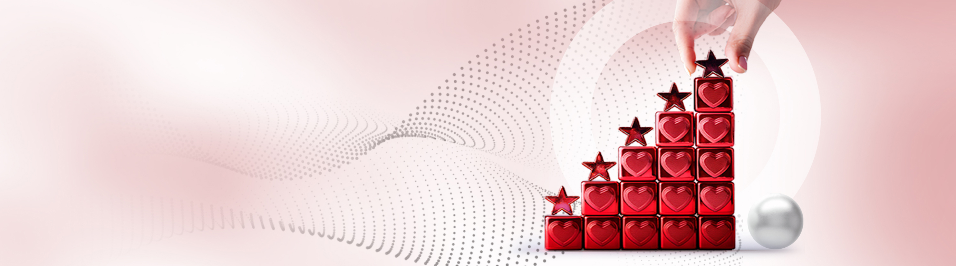 Illustrative – Hand placing star atop building blocks with hearts