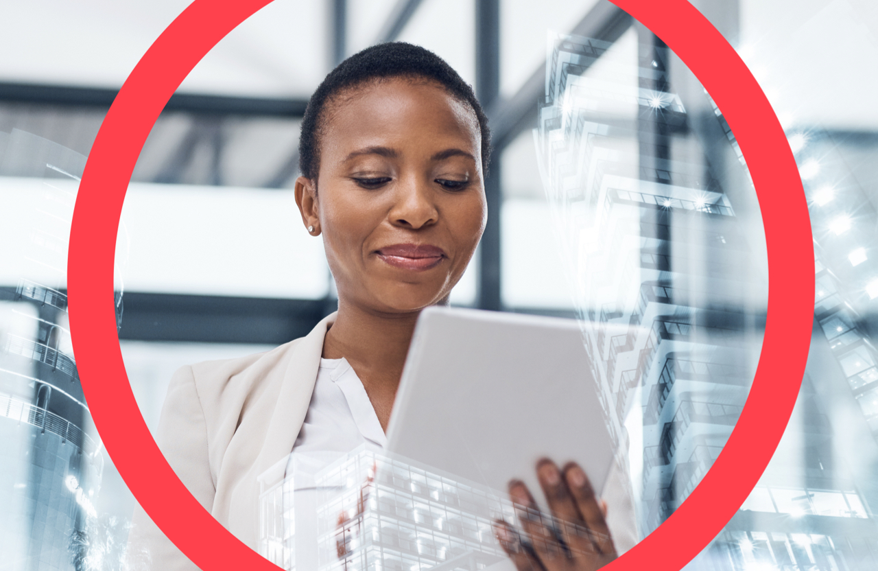 Woman holding tablet looking down against a background of glass windows reflecting office buildings