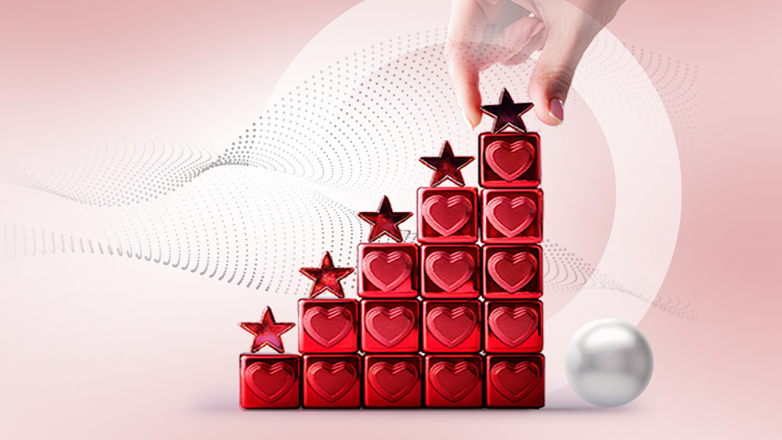 Illustrative – Hand placing star atop building blocks with hearts