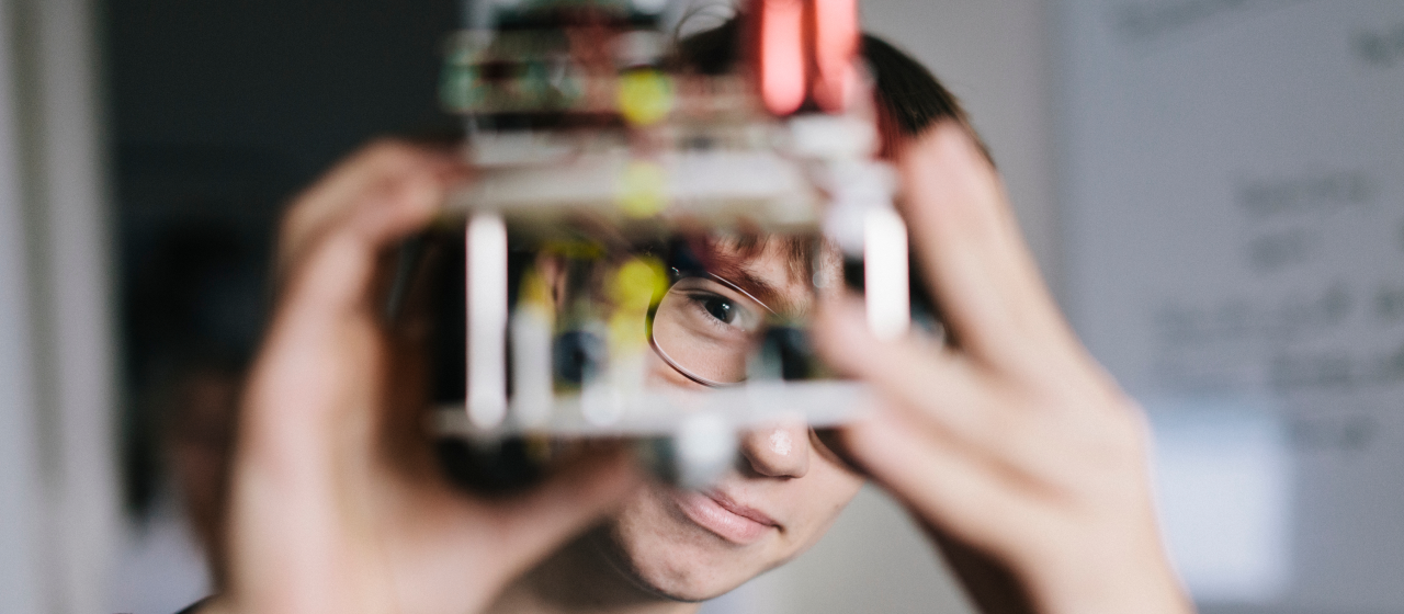 A man looking at a piece of machinery that he holds in his hands