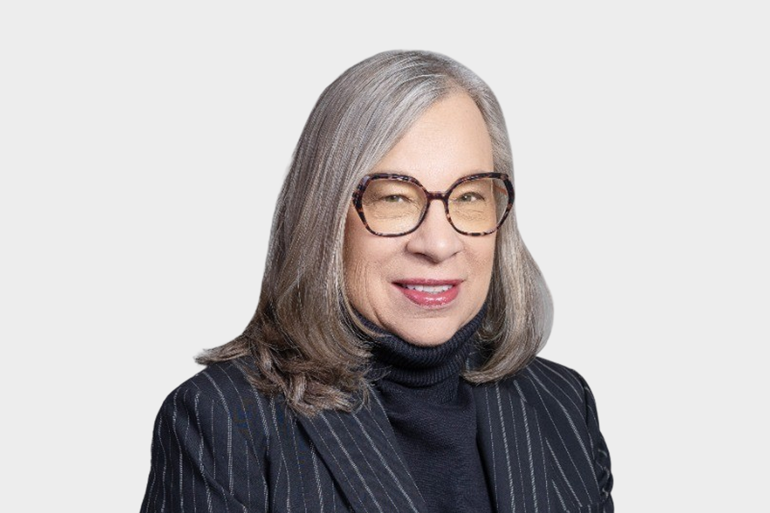 Photo of Janette Palwak smiling in a black blazer and black shirt with glasses 