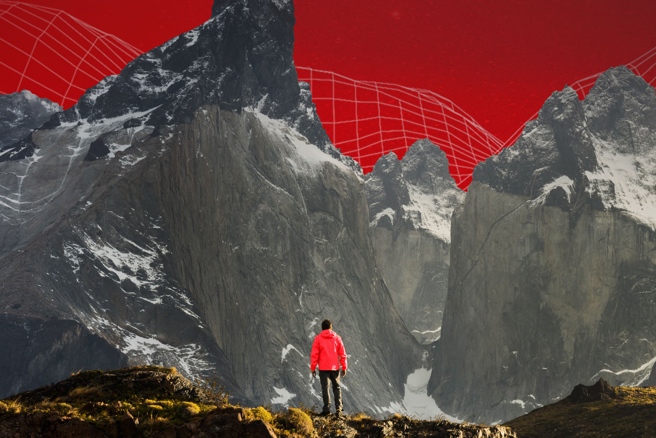 Person standing looking at mountain with red background